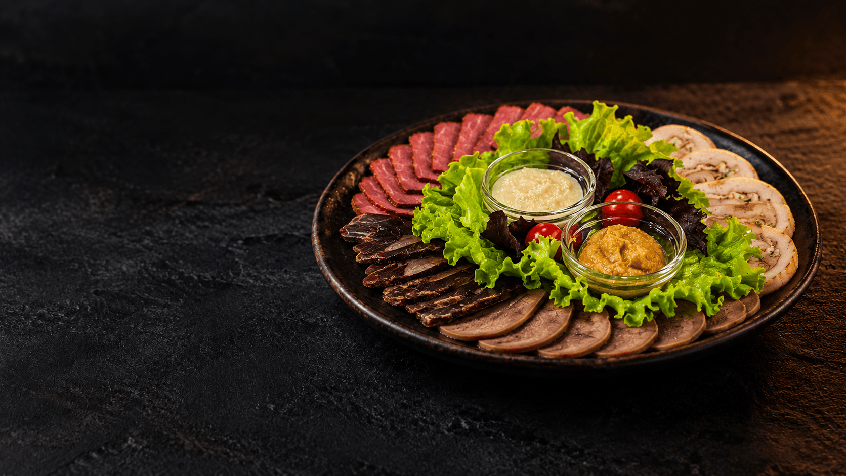 Ассорти мясных холодных закусок с зеленью и соусами